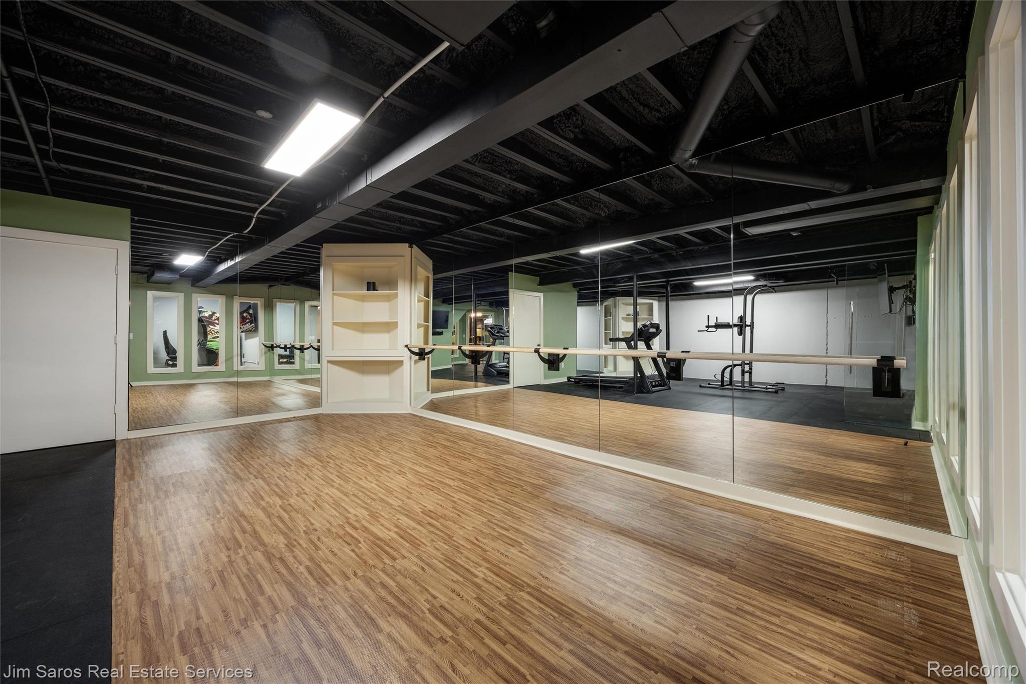910 Edgemont Park Grosse Pointe, MI 48230 - Photo 41 of 56 Spacious interior featuring wood-finish flooring, full-wall mirrors, built-in shelving, and a dark exposed ceiling