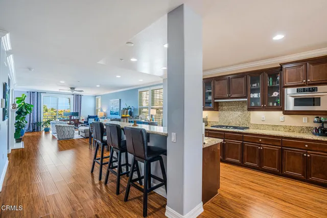a kitchen with stainless steel appliances granite countertop table chairs stove and cabinets