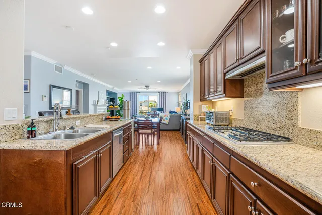 a kitchen with stainless steel appliances granite countertop a lot of counter space and wooden floors