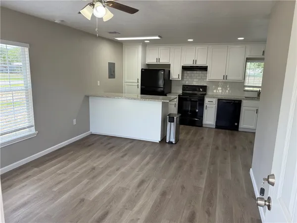 a view of kitchen with granite countertop cabinets and refrigerator