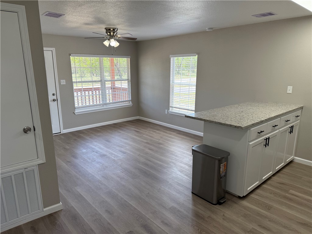 512 Wheeler Street Three Rivers, TX 78071 - Photo 3 of 19 an empty room with wooden floor cabinet and windows