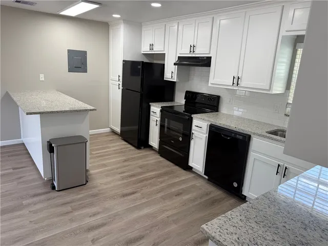 a kitchen with a refrigerator and a stove top oven