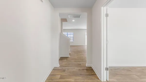 a view of a hallway with wooden floor
