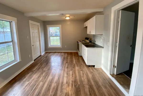 a kitchen with a wooden floor and a window