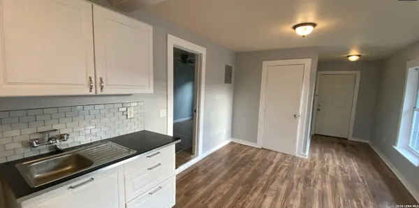 a kitchen with a sink and wooden floor