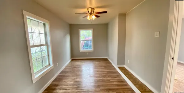 a view of a hallway with windows and chandelier fan