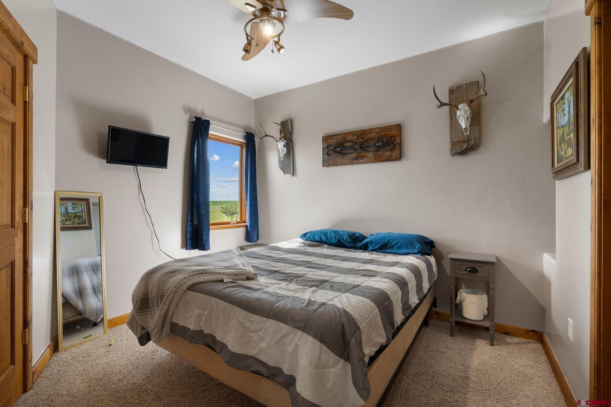 16132 Ee Road Pleasant View, CO 81331 - Photo 21 of 35 a bedroom with a bed and a flat screen tv