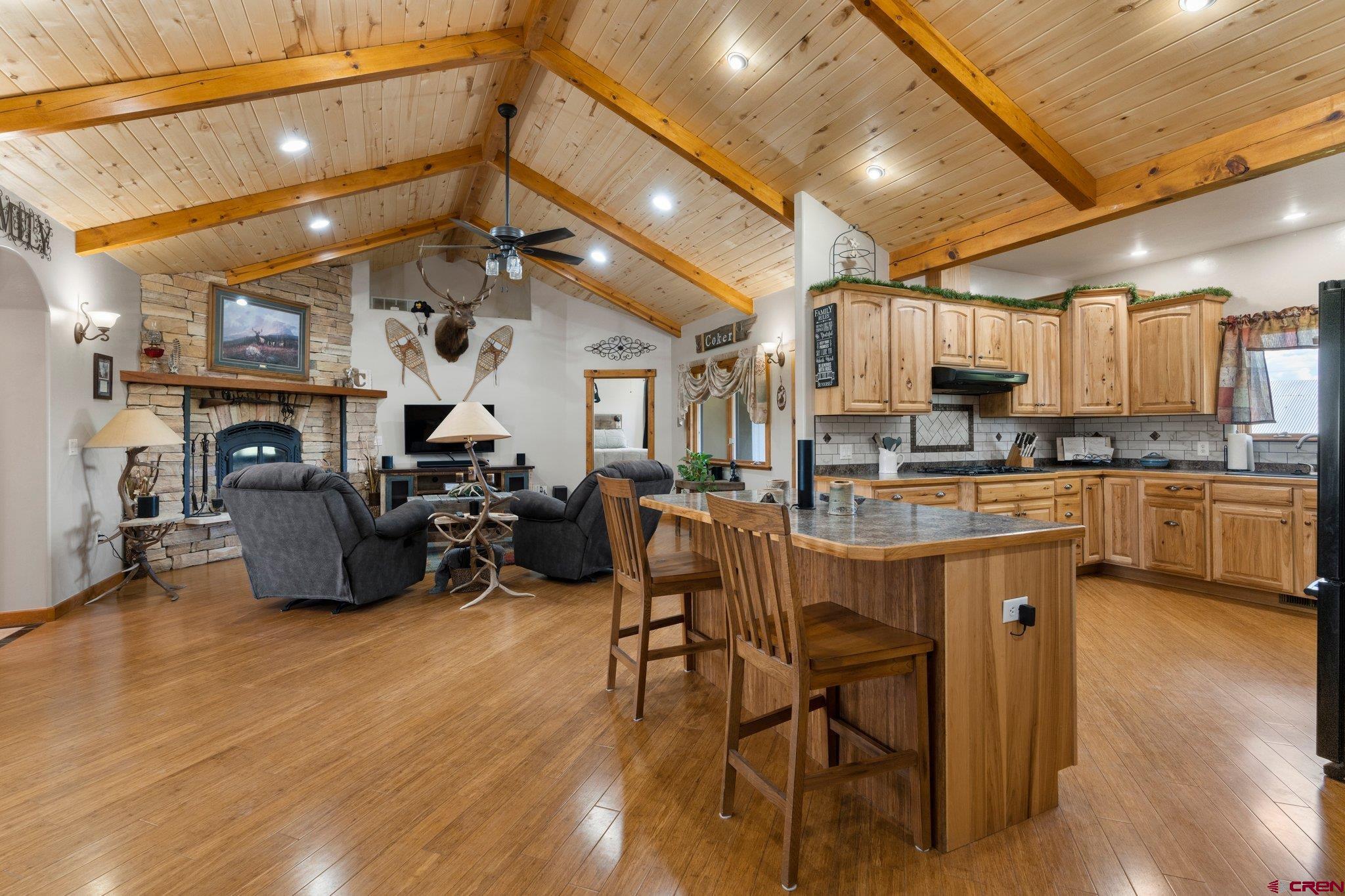 16132 Ee Road Pleasant View, CO 81331 - Photo 6 of 35 a kitchen with stainless steel appliances kitchen island granite countertop lots of wooden cabinets a dining table and chairs