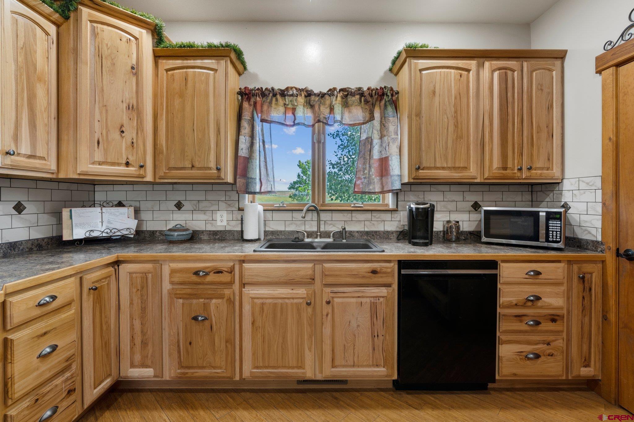 16132 Ee Road Pleasant View, CO 81331 - Photo 9 of 35 a kitchen with stainless steel appliances granite countertop a sink a stove and a microwave