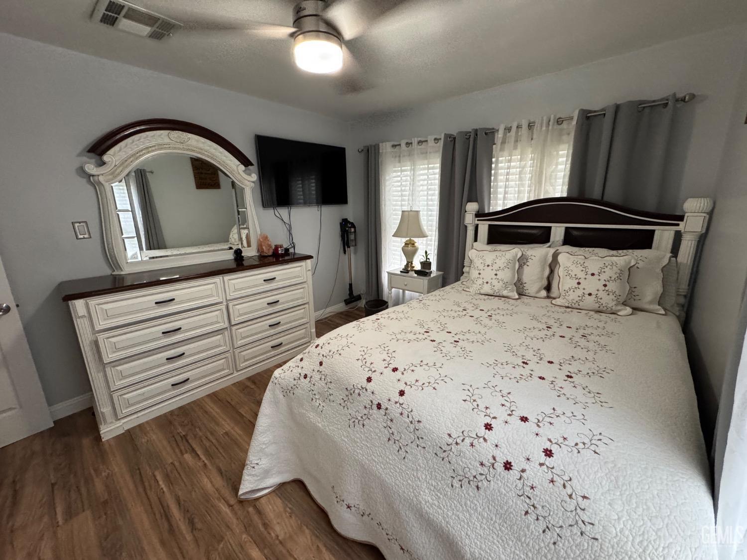 Undisclosed Address Bakersfield, CA 93304 - Photo 12 of 19 a bedroom with a bed and a mirror on dresser