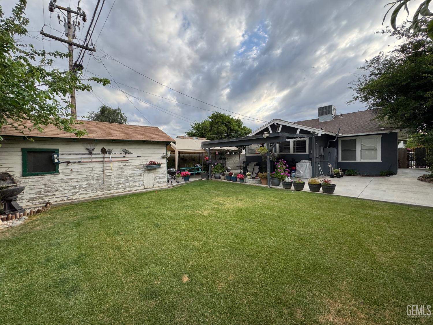 Undisclosed Address Bakersfield, CA 93304 - Photo 17 of 19 a view of a white house with a big yard and a large tree