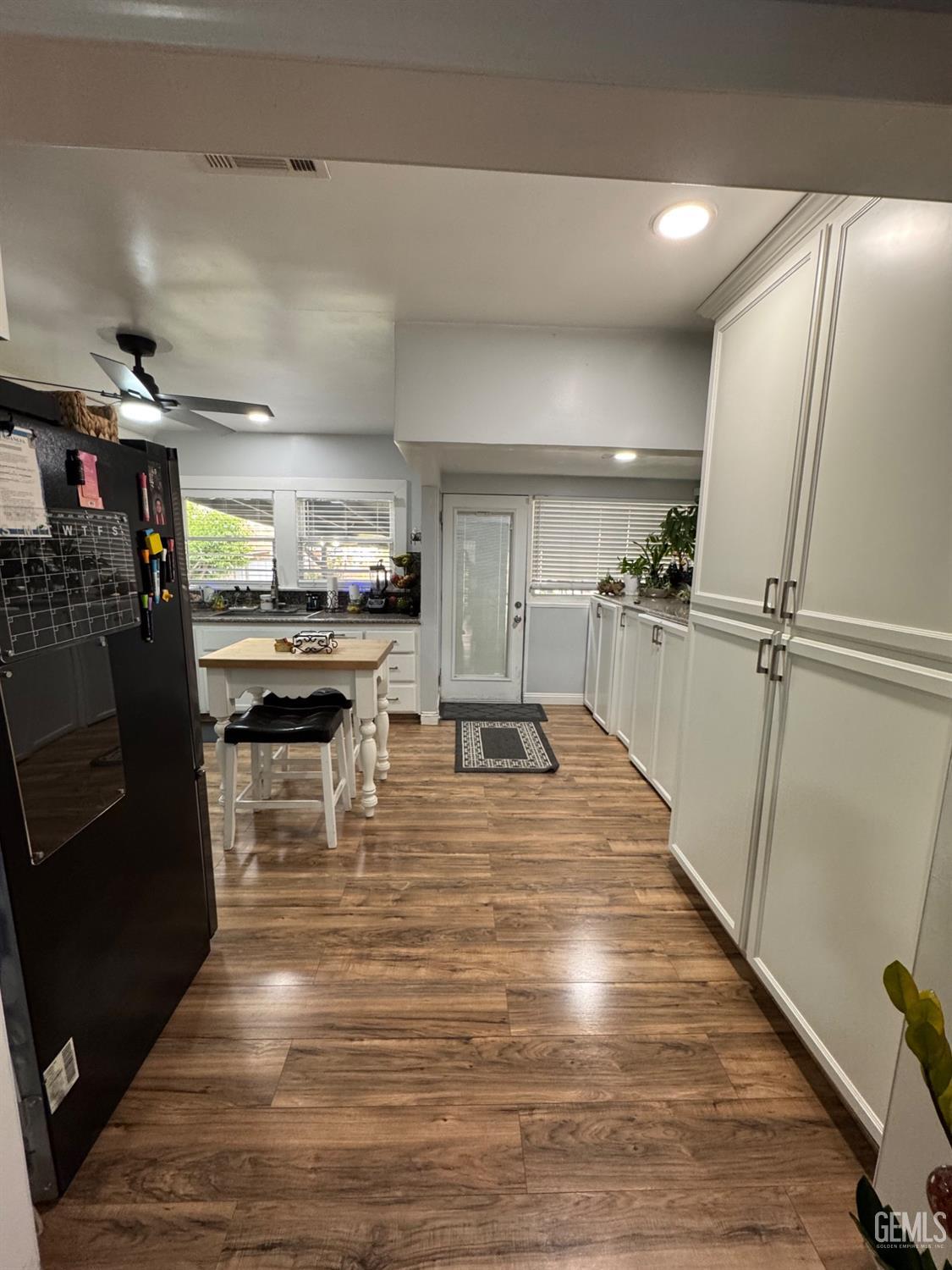 Undisclosed Address Bakersfield, CA 93304 - Photo 6 of 19 a view of a kitchen with kitchen island a counter top space wooden floor and stainless steel appliances