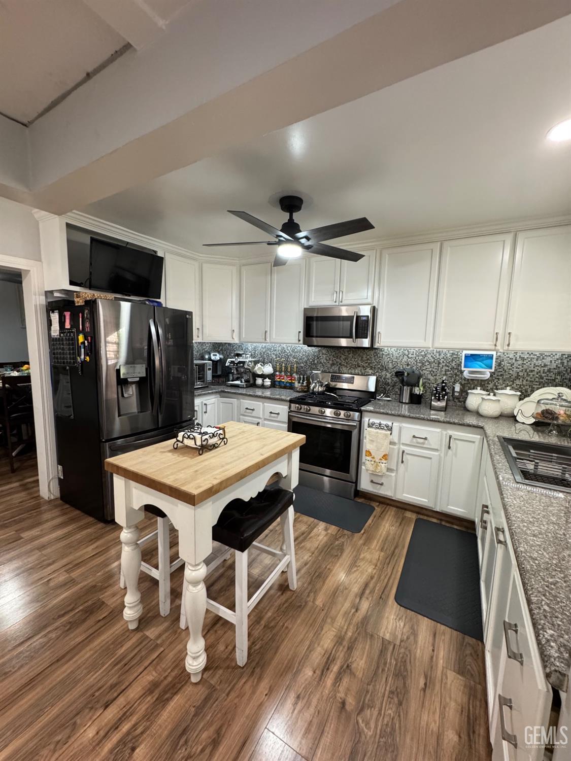 Undisclosed Address Bakersfield, CA 93304 - Photo 7 of 19 a kitchen with stainless steel appliances a stove a sink a refrigerator and a center island