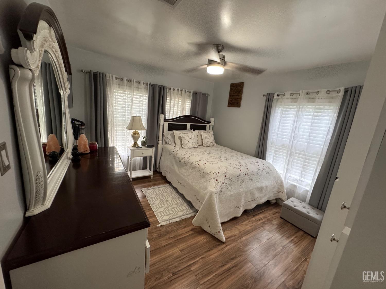 Undisclosed Address Bakersfield, CA 93304 - Photo 10 of 19 a bedroom with a large bed and a chandelier