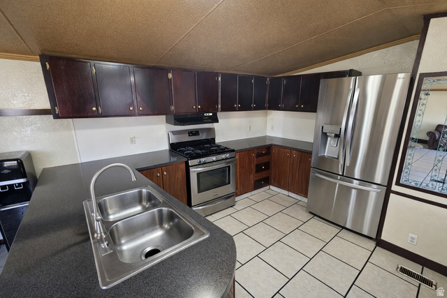 340 West 920 South, Unit 16 Provo, UT 84601 - Photo 5 of 15 Kitchen with dark countertops, stainless steel appliances, dark wood finish cabinets, extractor fan, and light tile patterned floors