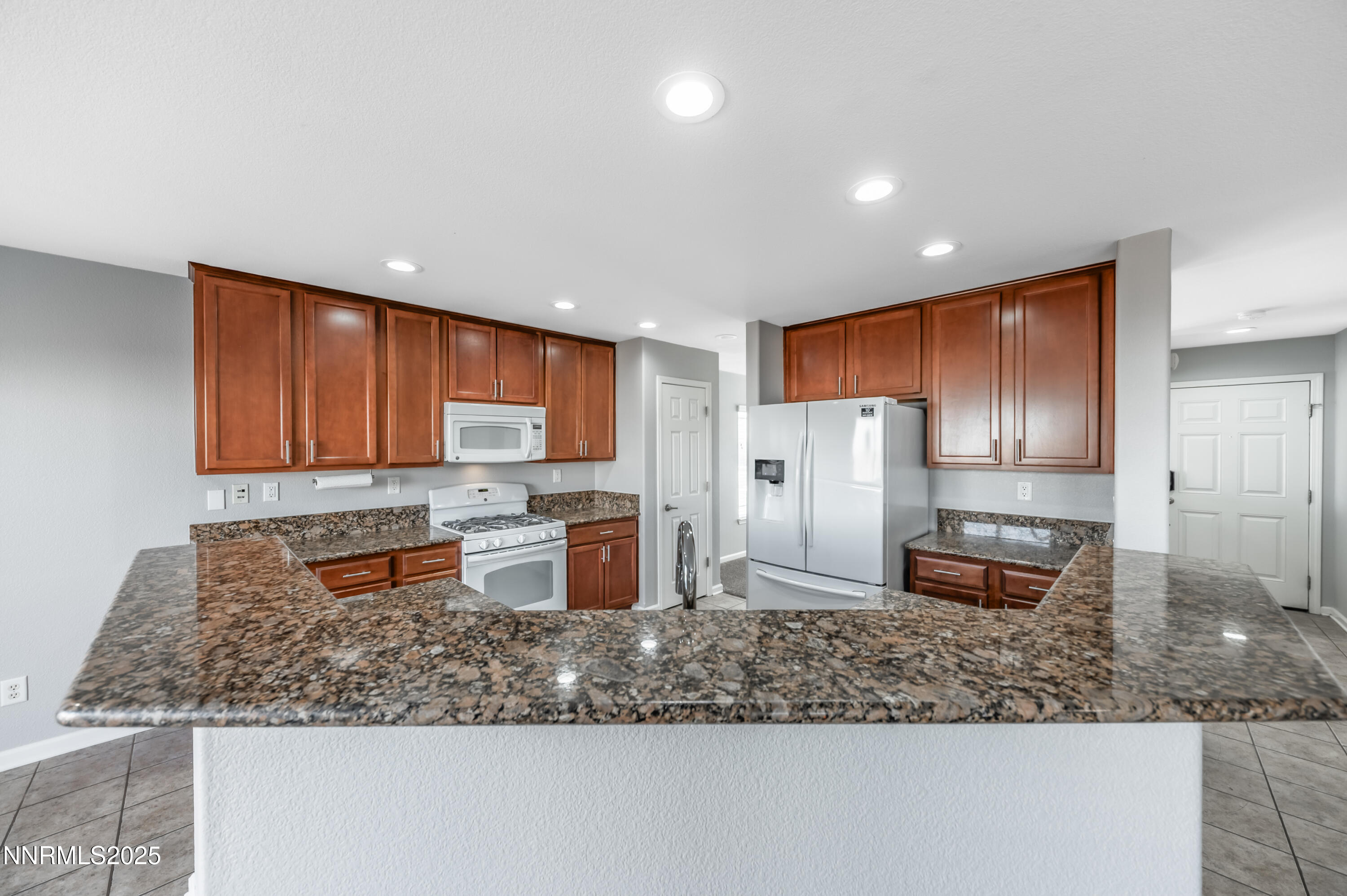 8905 Convair Way Reno, NV 89506 - Photo 13 of 38 a kitchen with stainless steel appliances granite countertop a refrigerator stove microwave and sink
