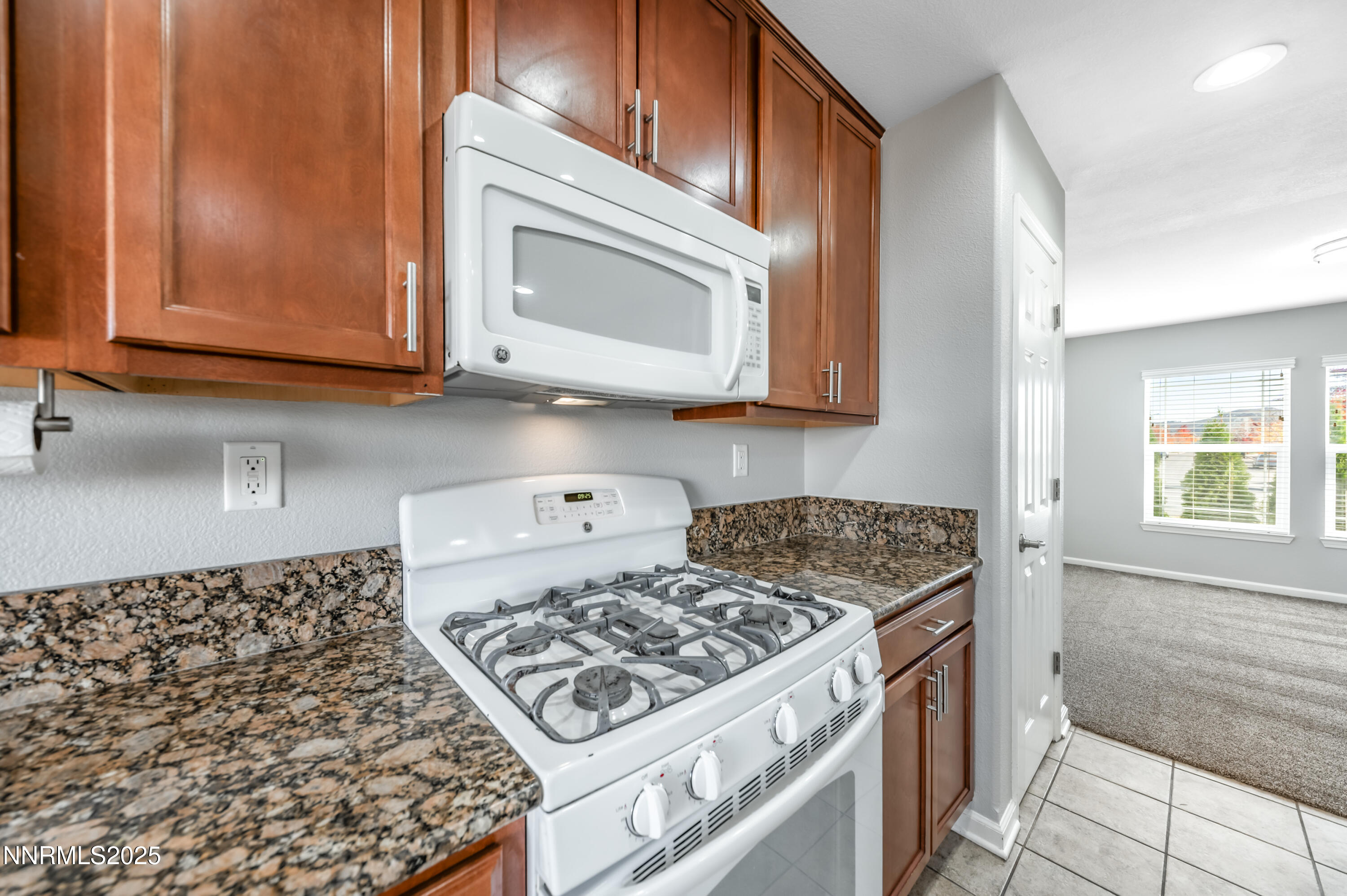 8905 Convair Way Reno, NV 89506 - Photo 14 of 38 a kitchen with stainless steel appliances granite countertop a stove a microwave a sink and cabinets