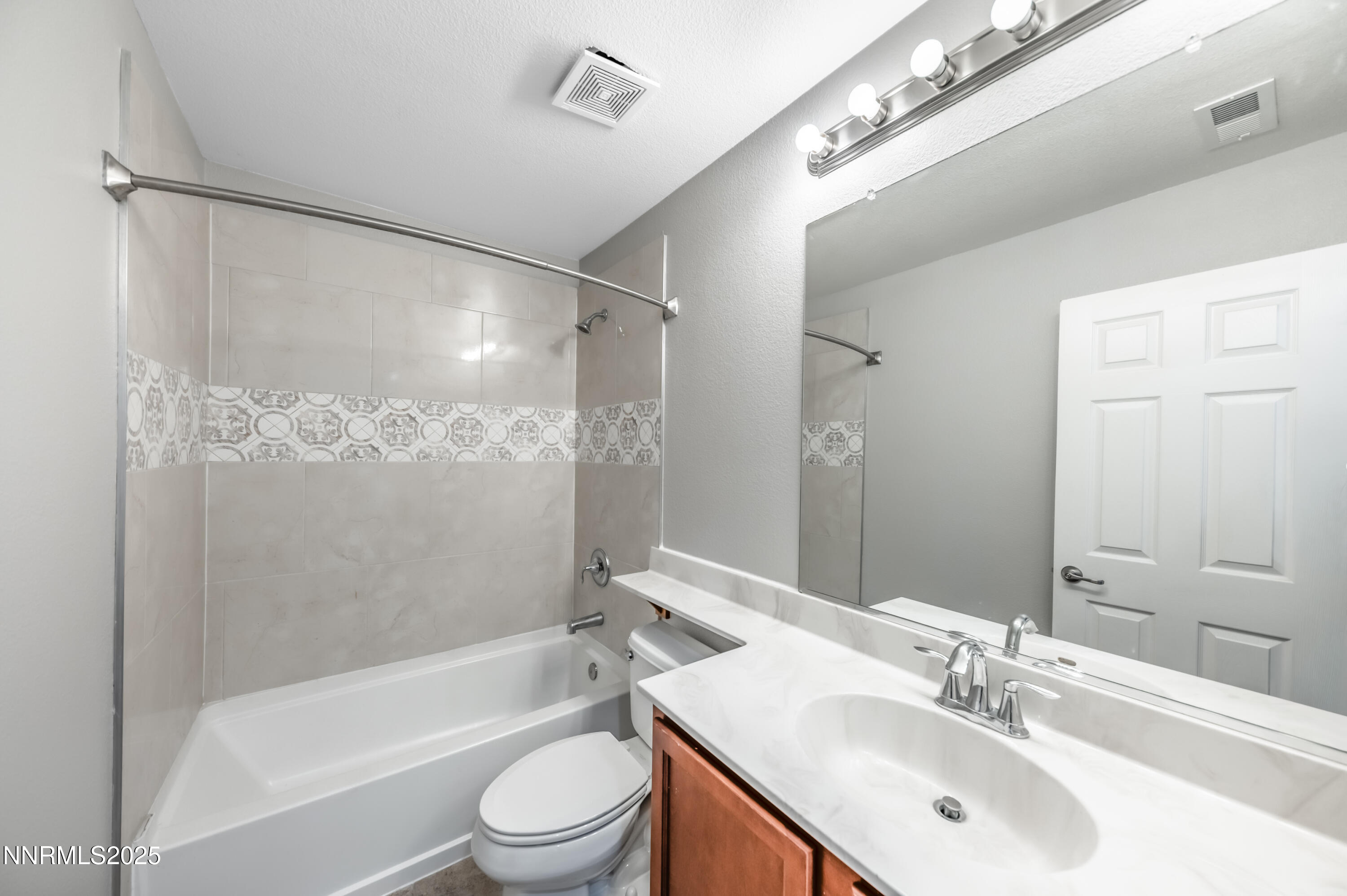 8905 Convair Way Reno, NV 89506 - Photo 29 of 38 a bathroom with a bathtub shower sink vanity mirror and toilet