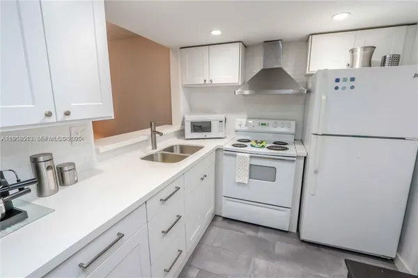 a kitchen with white cabinets and white appliances