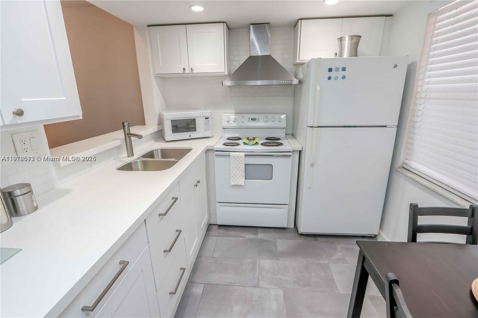 9150 Lime Bay Boulevard, Unit 212 Tamarac, FL 33321 - Photo 13 of 21 a kitchen with stainless steel appliances a refrigerator sink and cabinets