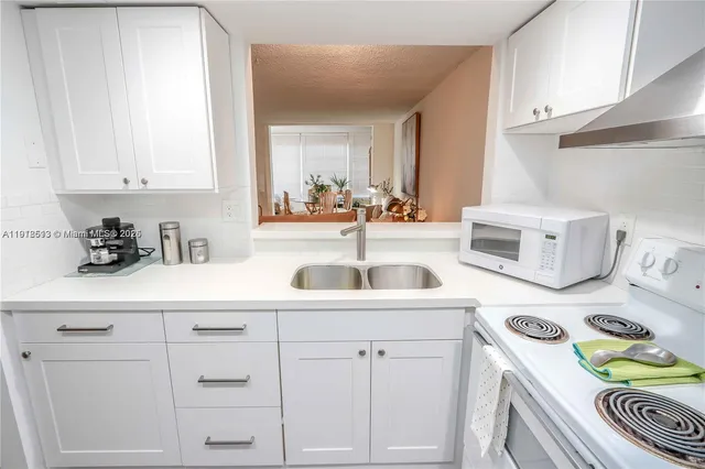 a kitchen with white cabinets and white appliances