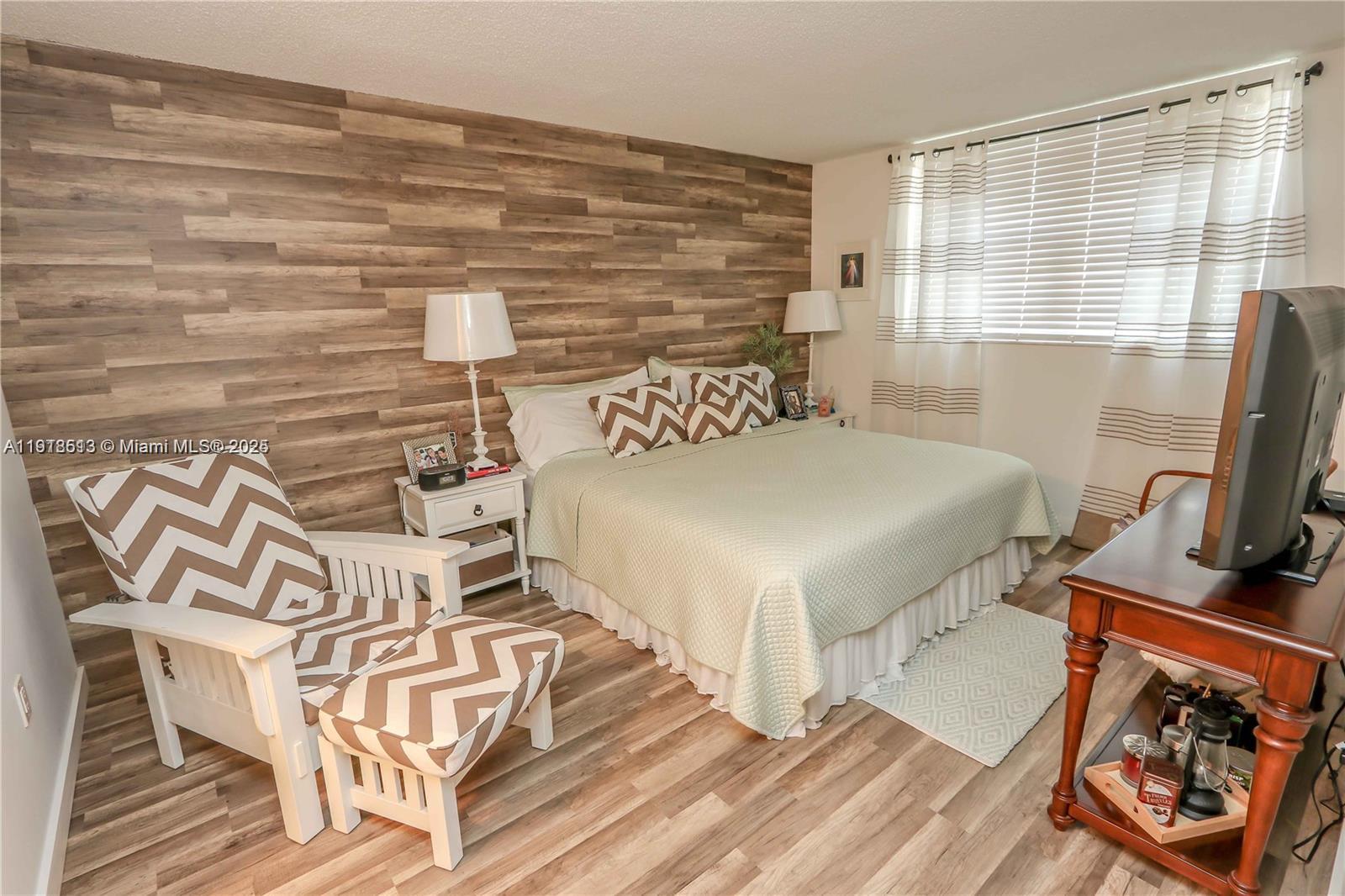 9150 Lime Bay Boulevard, Unit 212 Tamarac, FL 33321 - Photo 16 of 21 a bedroom with a bed and wooden floor