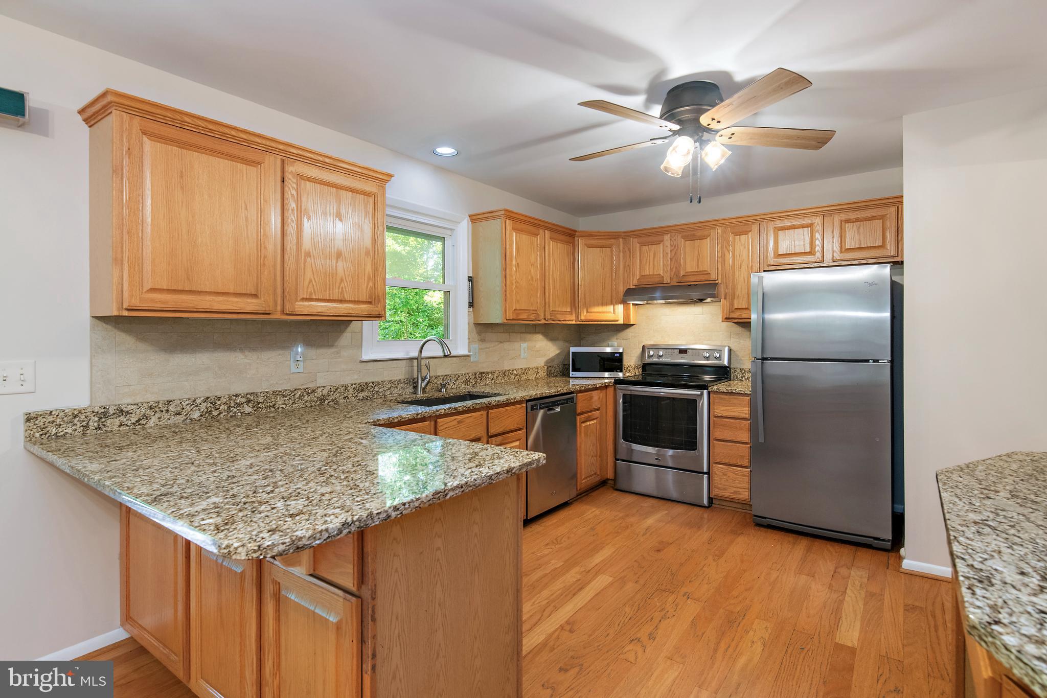 1701 Underwood Road Gambrills, MD 21054 - Photo 30 of 62 a kitchen with granite countertop a refrigerator a sink a stove and island