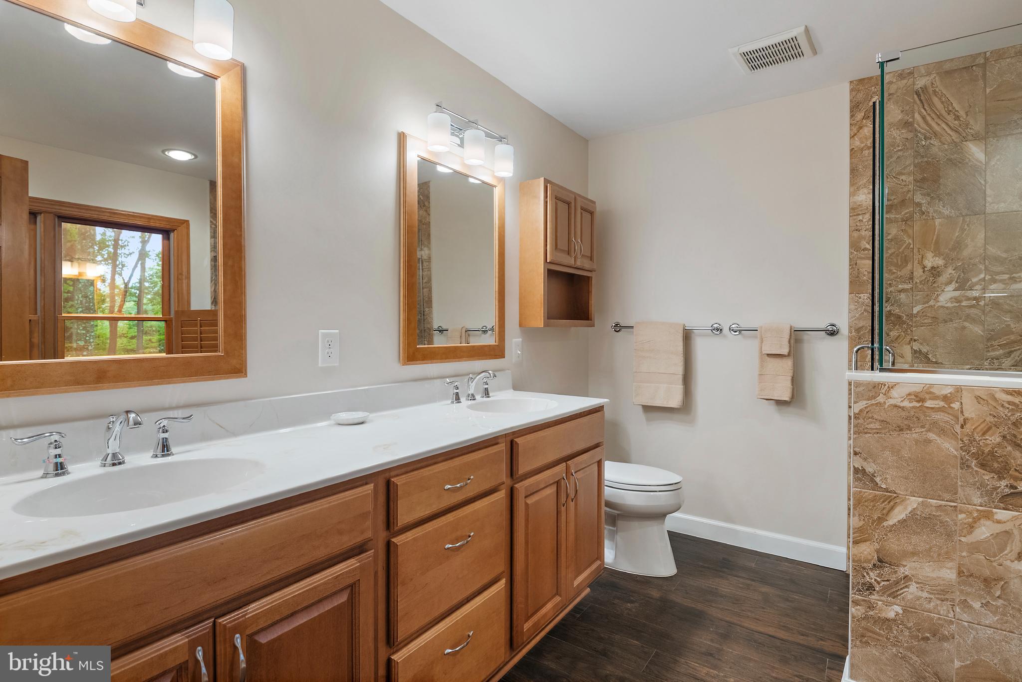 1701 Underwood Road Gambrills, MD 21054 - Photo 36 of 62 a bathroom with a double vanity sink toilet mirror and shower