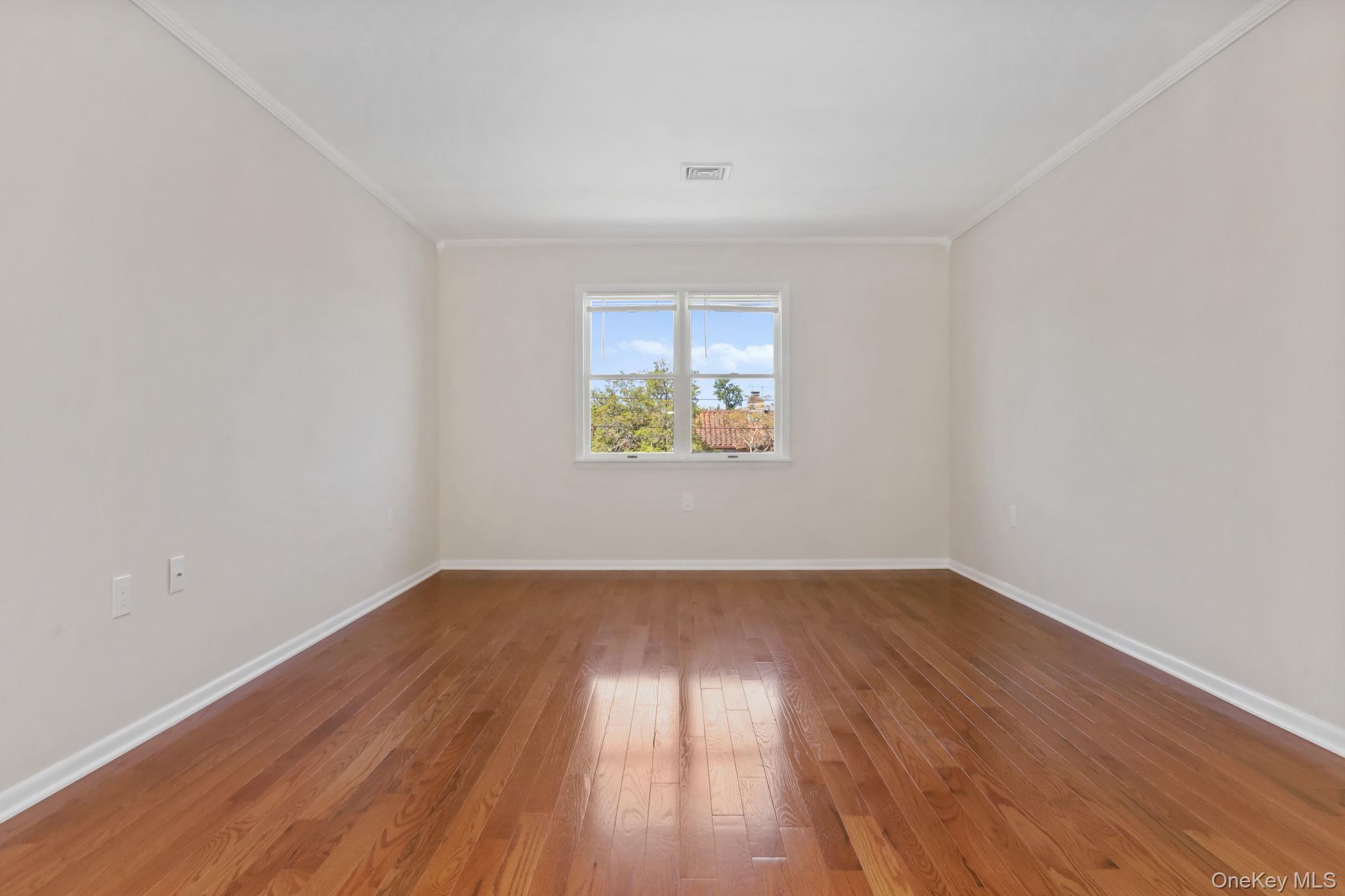 160 Lakeview Avenue, Unit 2 West Harrison, NY 10604 - Photo 4 of 19 an empty room with wooden floor and windows
