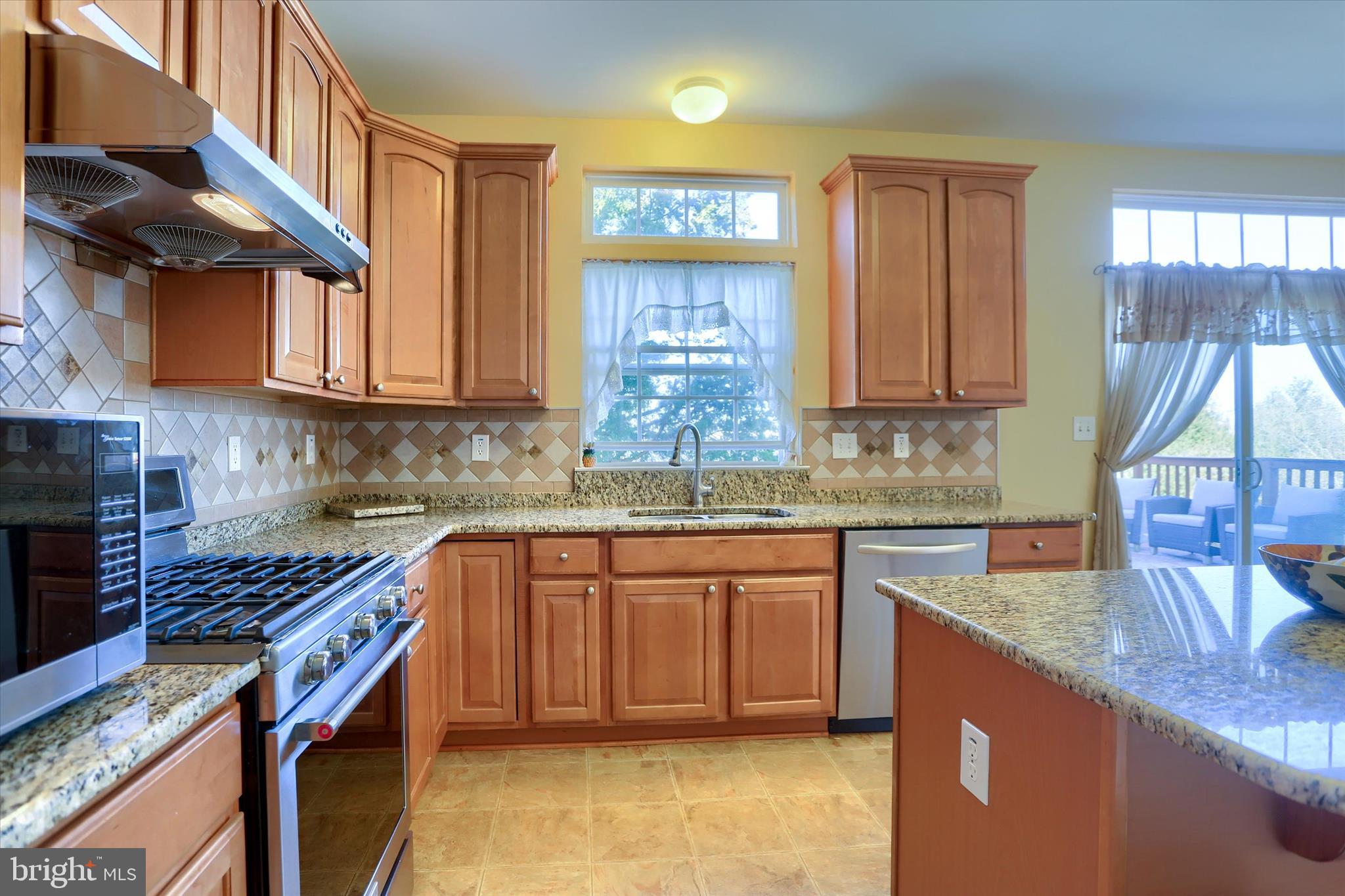 409 Wynwood Road York, PA 17402 - Photo 19 of 64 a kitchen with granite countertop a sink a stove and cabinets