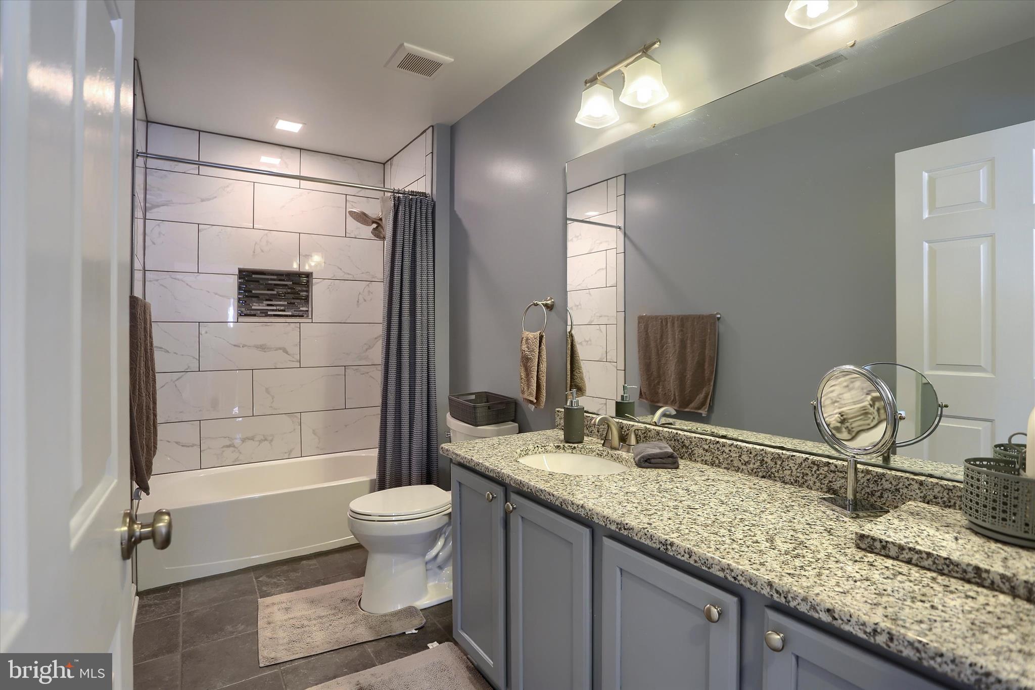 409 Wynwood Road York, PA 17402 - Photo 39 of 64 a bathroom with a granite countertop sink a toilet a mirror and shower