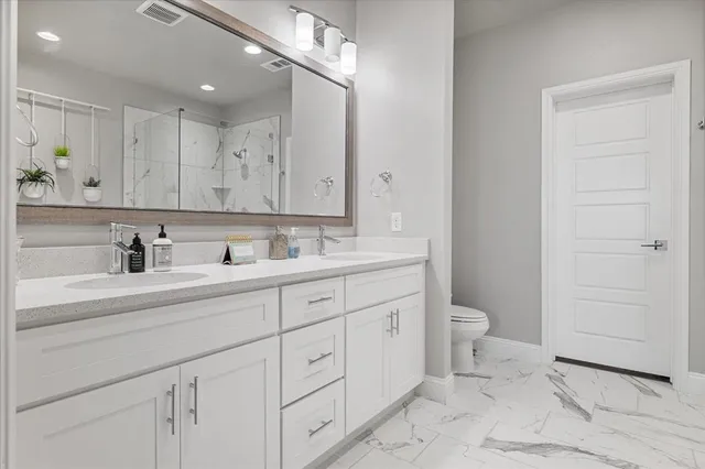 a bathroom with a sink a toilet and shower