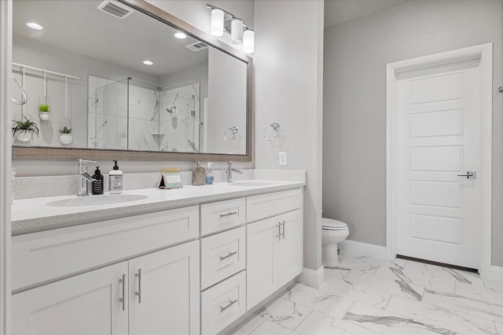 6013 Page Street Frisco, TX 75034 - Photo 29 of 39 a bathroom with a sink a toilet and mirror