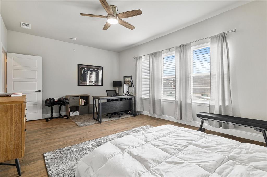 6013 Page Street Frisco, TX 75034 - Photo 35 of 39 a spacious bedroom with a bed a table and a large window