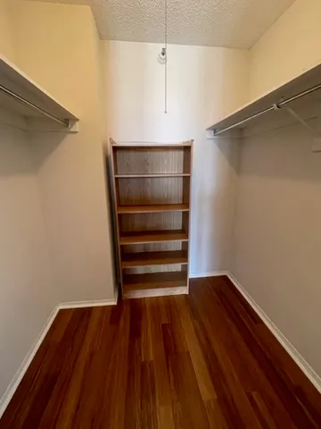 a bedroom with a bed television on desk and a window