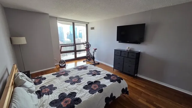 a bedroom with a bed and a flat tv screen on a dresser
