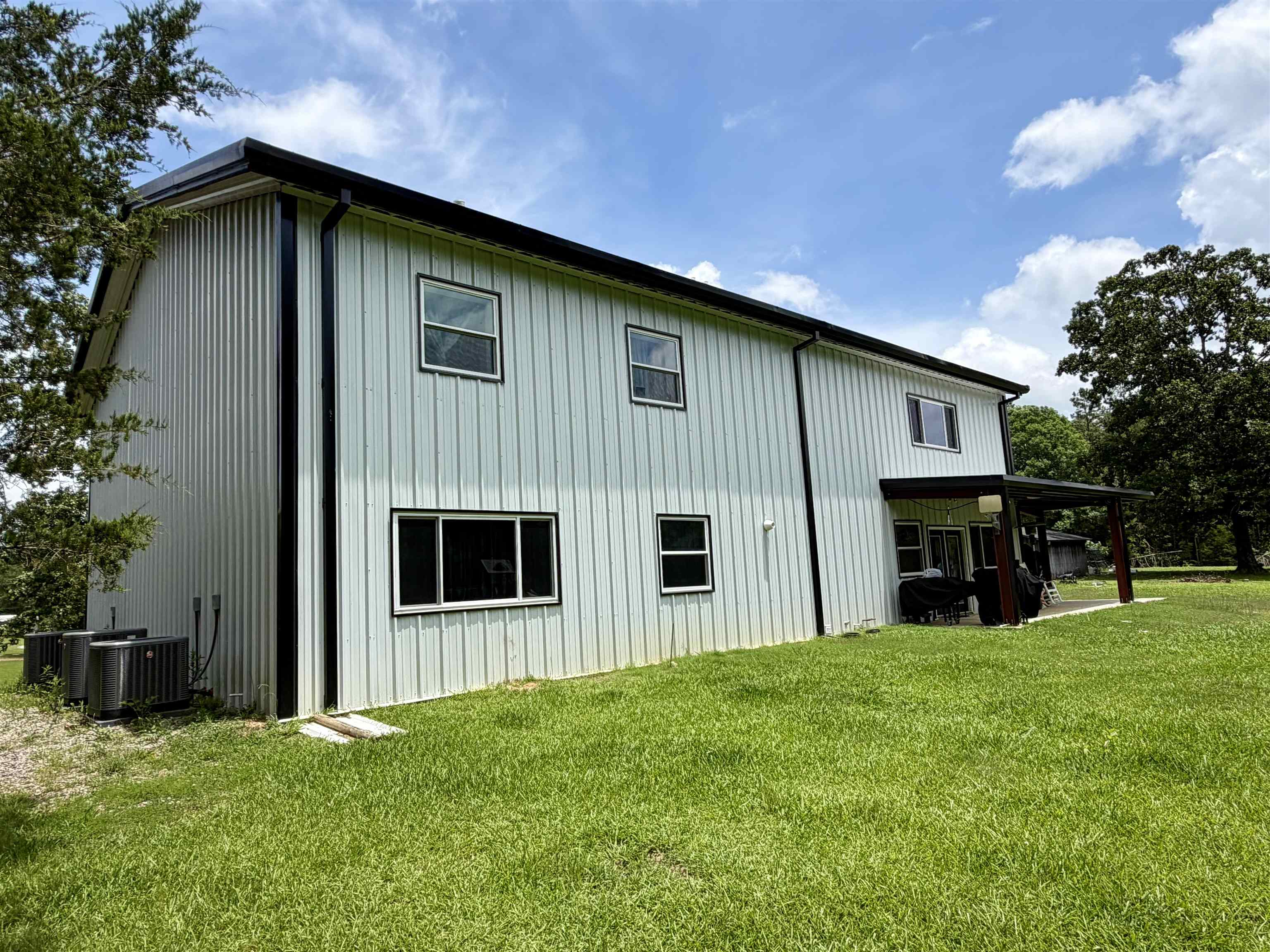3670 Peavine Road Middleton, TN 38052 - Photo 34 of 36 Two-story residence featuring vertical metal siding, black trim accents, and a covered back patio