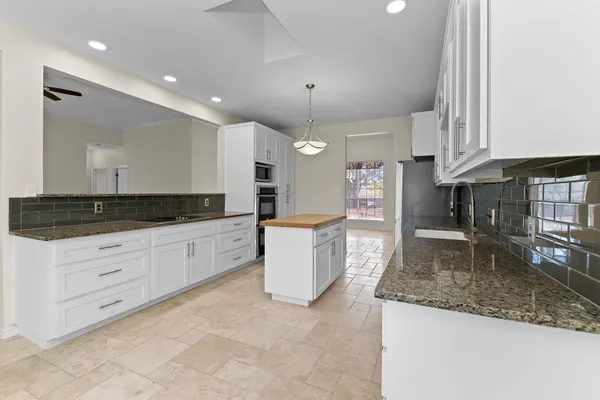 a large kitchen with stainless steel appliances granite countertop a granite counter tops and a stove