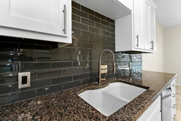 a bathroom with a granite countertop sink a vanity and a blue shower