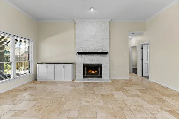 a view of an empty room with a fireplace and a window