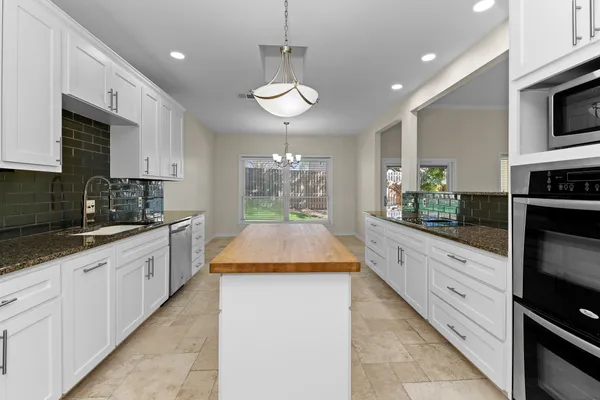 a large kitchen with stainless steel appliances granite countertop a sink and a stove