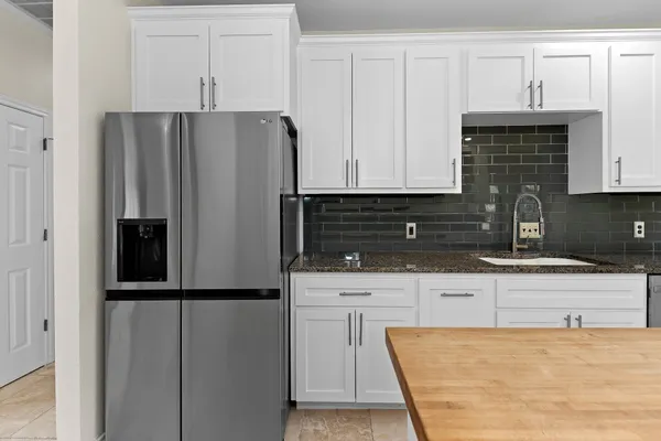 a kitchen with stainless steel appliances granite countertop a refrigerator and a sink