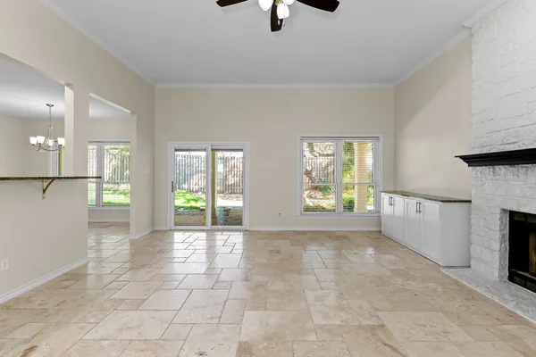 a view of an empty room with a fireplace and a window