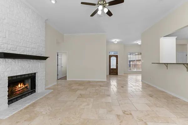 a view of a livingroom with a fireplace a cabinet and windows