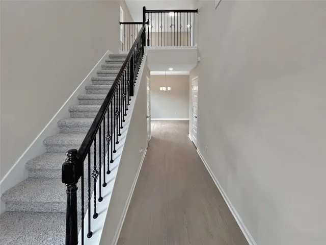 a view of staircase with wooden floor and white walls