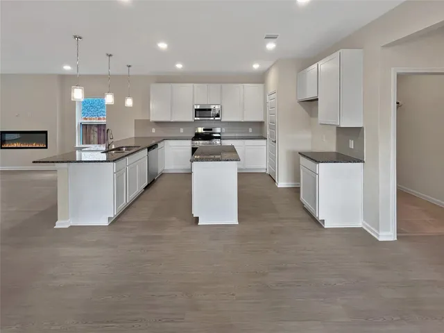 an empty room with windows and fireplace
