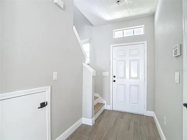 a kitchen with white cabinets a sink stove and microwave oven with wooden floor