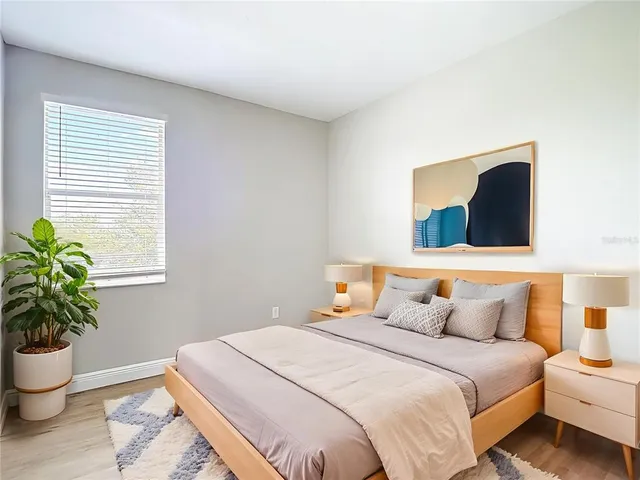 a bedroom with a bed and a lamp on dresser