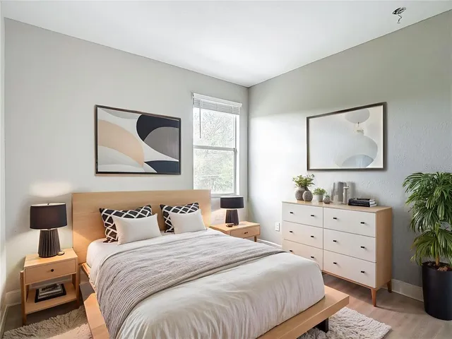 a bedroom with a bed and a lamp on dresser