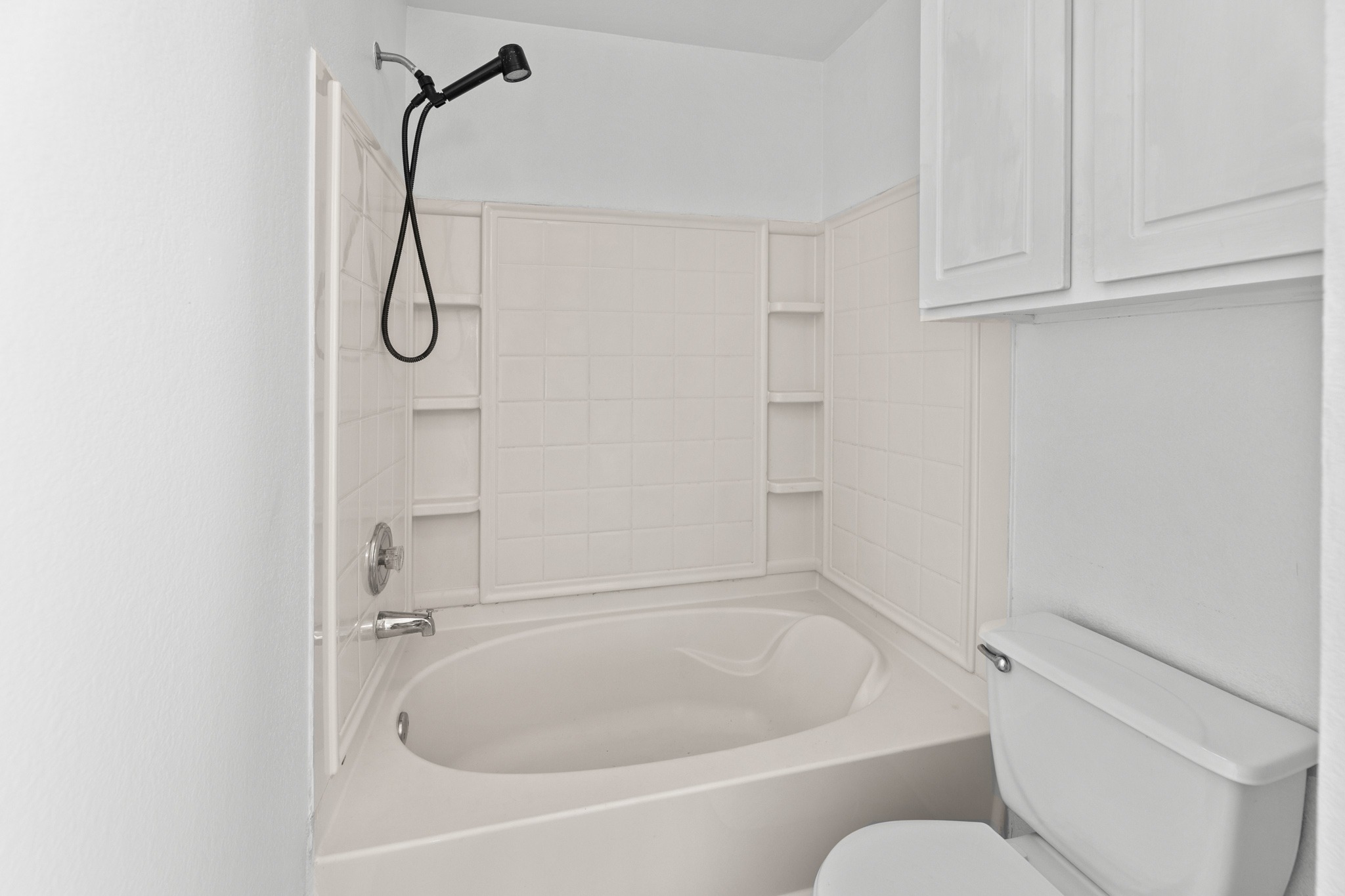 722 Lavaca Loop Elgin, TX 78621 - Photo 18 of 35 A deep soaking tub paired with tiled surround finishes this crisp bathroom design.